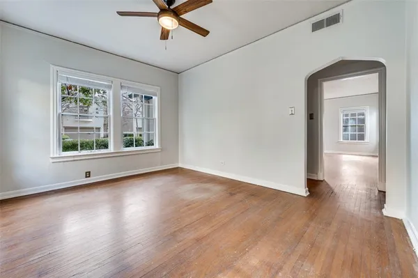 a view of a livingroom with wooden floor and a ceiling fan