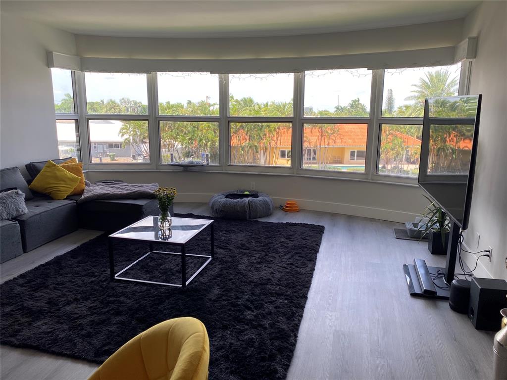 3031 Northeast 51st Street, Unit 305W Fort Lauderdale, FL 33308 - Photo 2 of 11 a living room with furniture and a floor to ceiling window