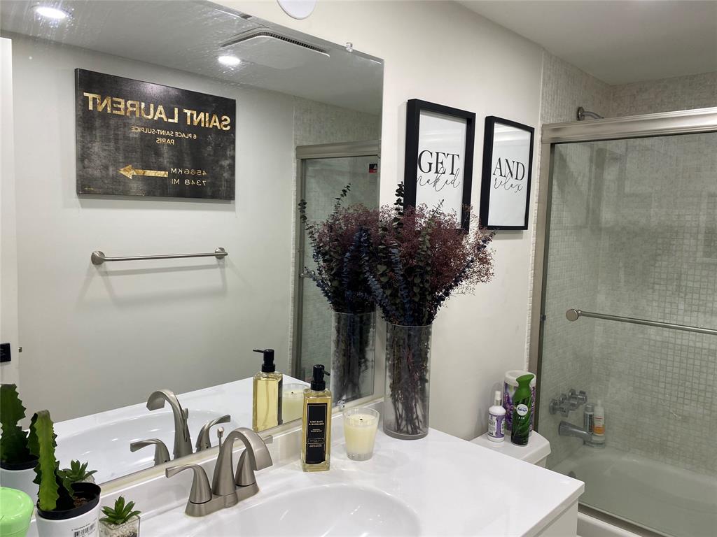 3031 Northeast 51st Street, Unit 305W Fort Lauderdale, FL 33308 - Photo 6 of 11 a bathroom with a sink a mirror and a shower