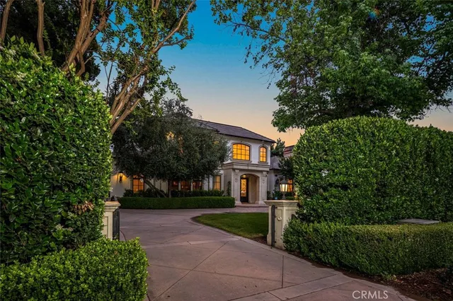 a front view of a house with a yard and tree s