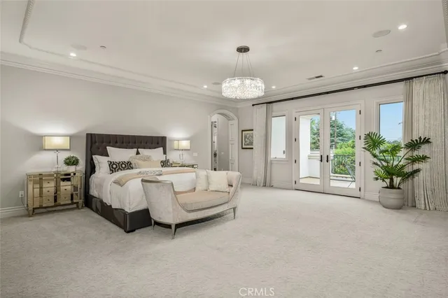 a bedroom with a large bed and a chandelier