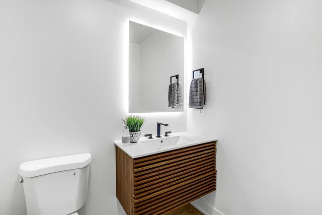 a bathroom with a sink a toilet and mirror