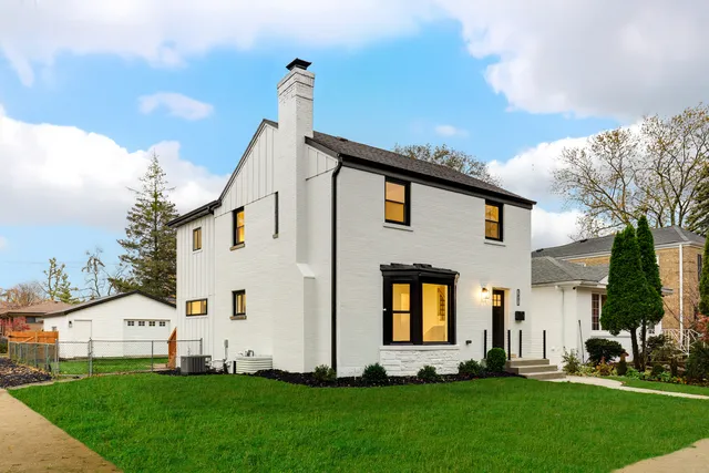 a front view of a house with a garden and plants