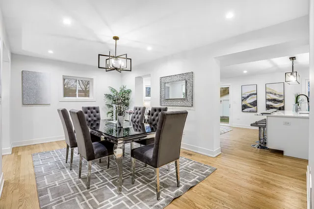 a view of a dining room with furniture a rug and wooden floor