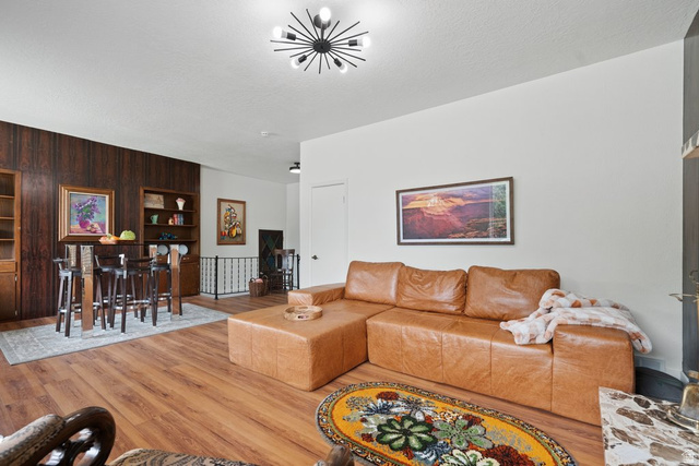 673 East 700 South Springville, UT 84663 - Photo 10 of 43 Open-concept living area featuring wood-finish flooring, a contemporary ceiling light fixture, and a built-in shelving unit