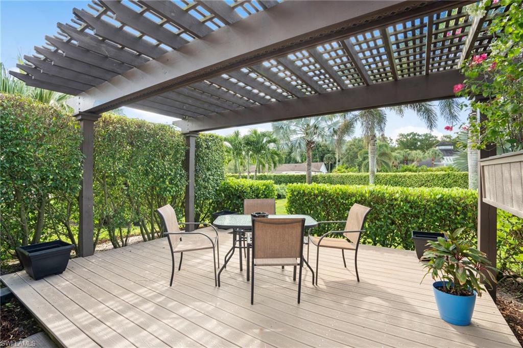 101 Muirfield Circle Naples, FL 34113 - Photo 8 of 27 Side deck with pergola surrounded by lush landscaping for a more private retreat.