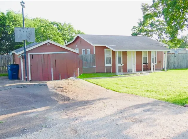 a view of a house with a yard and large tree