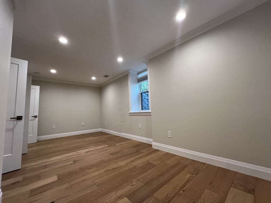 23 Winslow Road, Unit 1 Brookline, MA 02446 - Photo 18 of 27 an empty room with wooden floor and windows