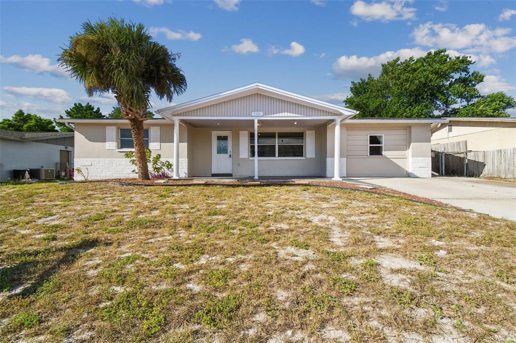 a front view of house with yard and trees in the background