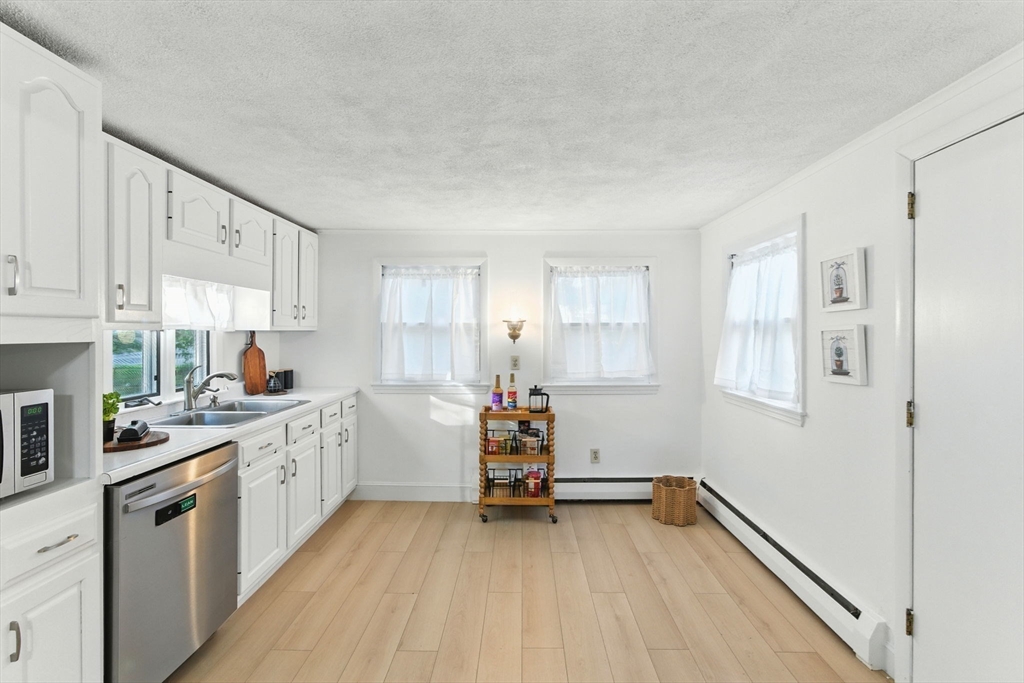 53 Park Street North Reading, MA 01864 - Photo 6 of 24 a kitchen that has a lot of cabinets in it and wooden floors