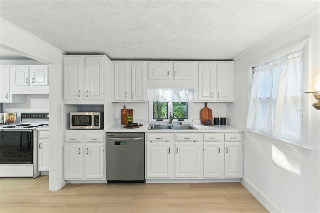 53 Park Street North Reading, MA 01864 - Photo 7 of 24 a kitchen with white cabinets sink and stainless steel appliances