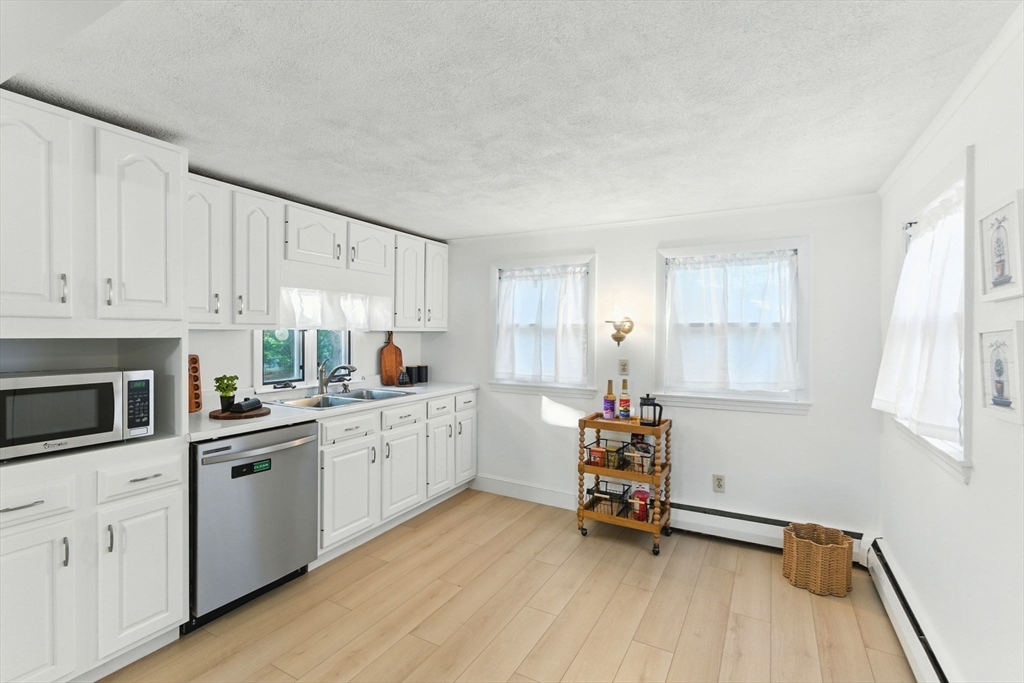 53 Park Street North Reading, MA 01864 - Photo 8 of 24 a kitchen with white cabinets and window