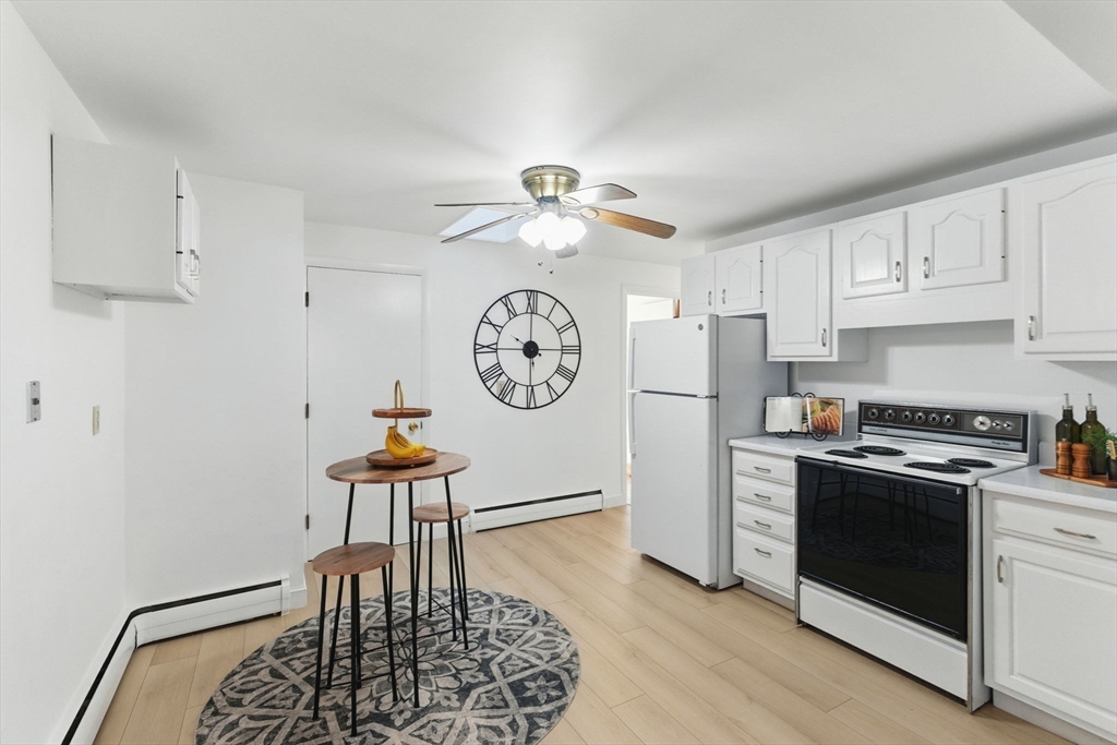 53 Park Street North Reading, MA 01864 - Photo 10 of 24 a kitchen with stainless steel appliances granite countertop a stove a refrigerator a dining table and chairs with wooden floor