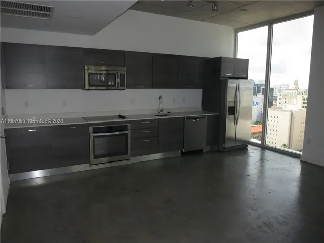 a kitchen with stainless steel appliances a sink a stove and a refrigerator