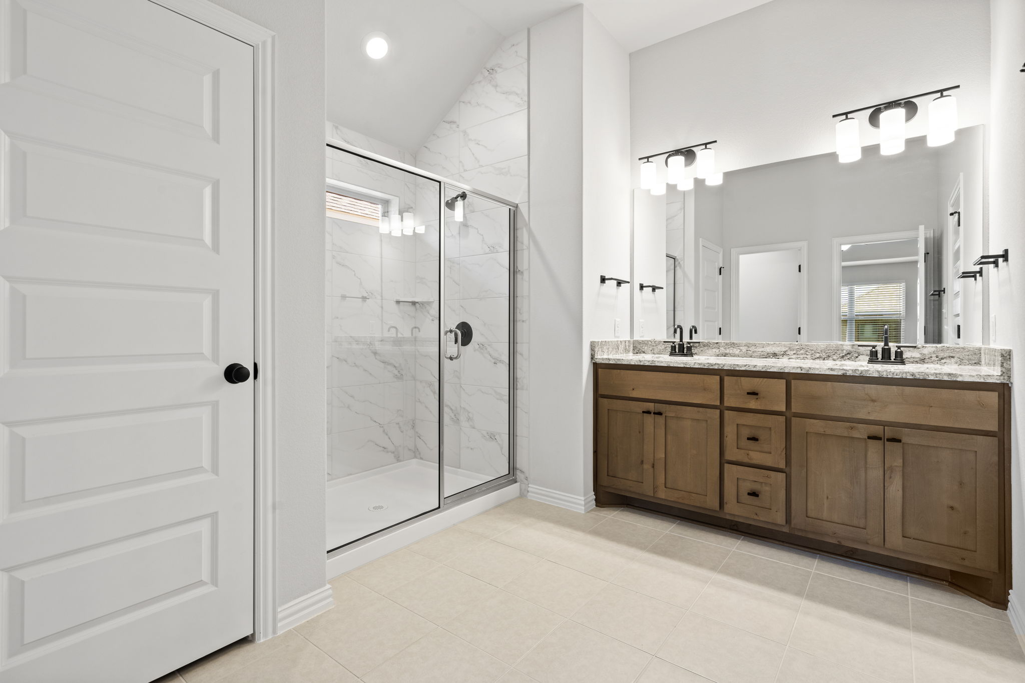 341 Fawn Riv Run Kyle, TX 78640 - Photo 12 of 29 Full bath with a healthy amount of sunlight, a sink, double vanity, and a marble finish shower