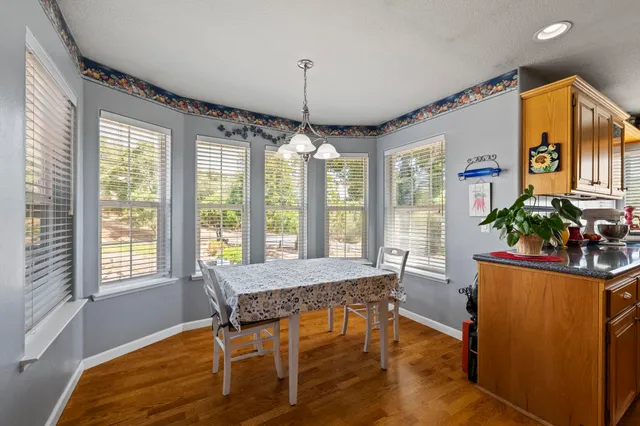 a kitchen with stainless steel appliances granite countertop table chairs and a refrigerator