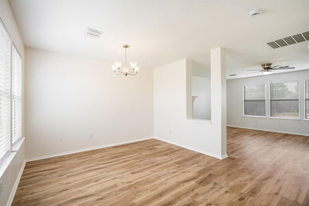 1626 White Oak Road Anna, TX 75409 - Photo 13 of 30 an empty room with wooden floor cabinet and windows
