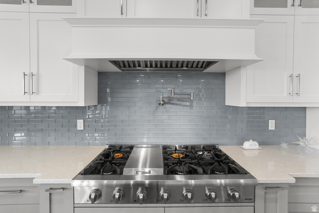 1354 South 800 East Mapleton, UT 84664 - Photo 21 of 129 Kitchen with range hood, light stone counters, high end stainless steel range, decorative backsplash, and white cabinetry
