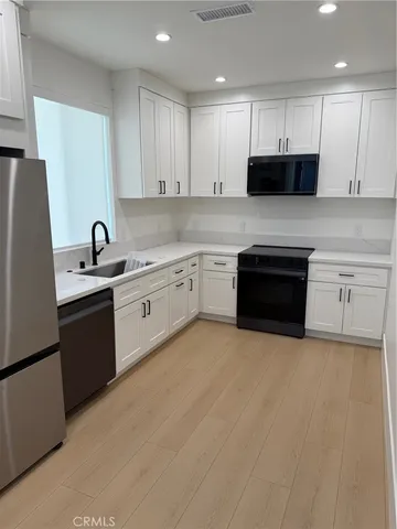 a kitchen with granite countertop a sink stove and cabinets