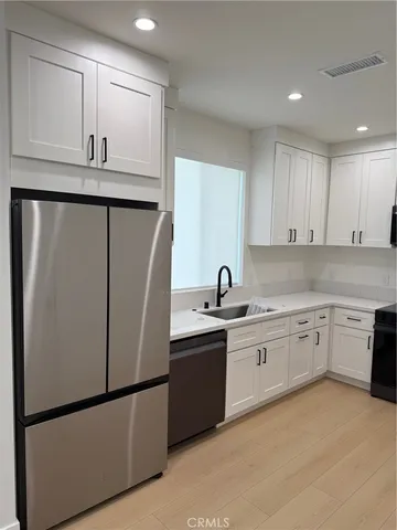 a kitchen with stainless steel appliances granite countertop refrigerator sink and cabinets