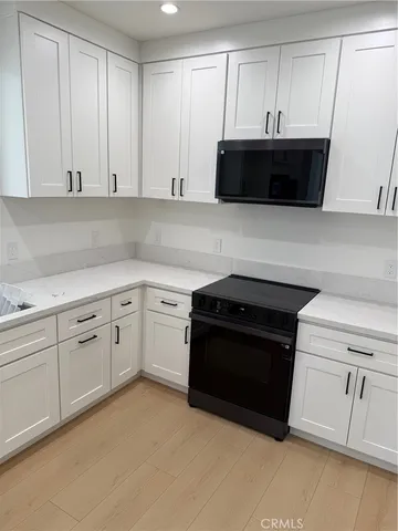 a kitchen with stainless steel appliances white cabinets and a sink