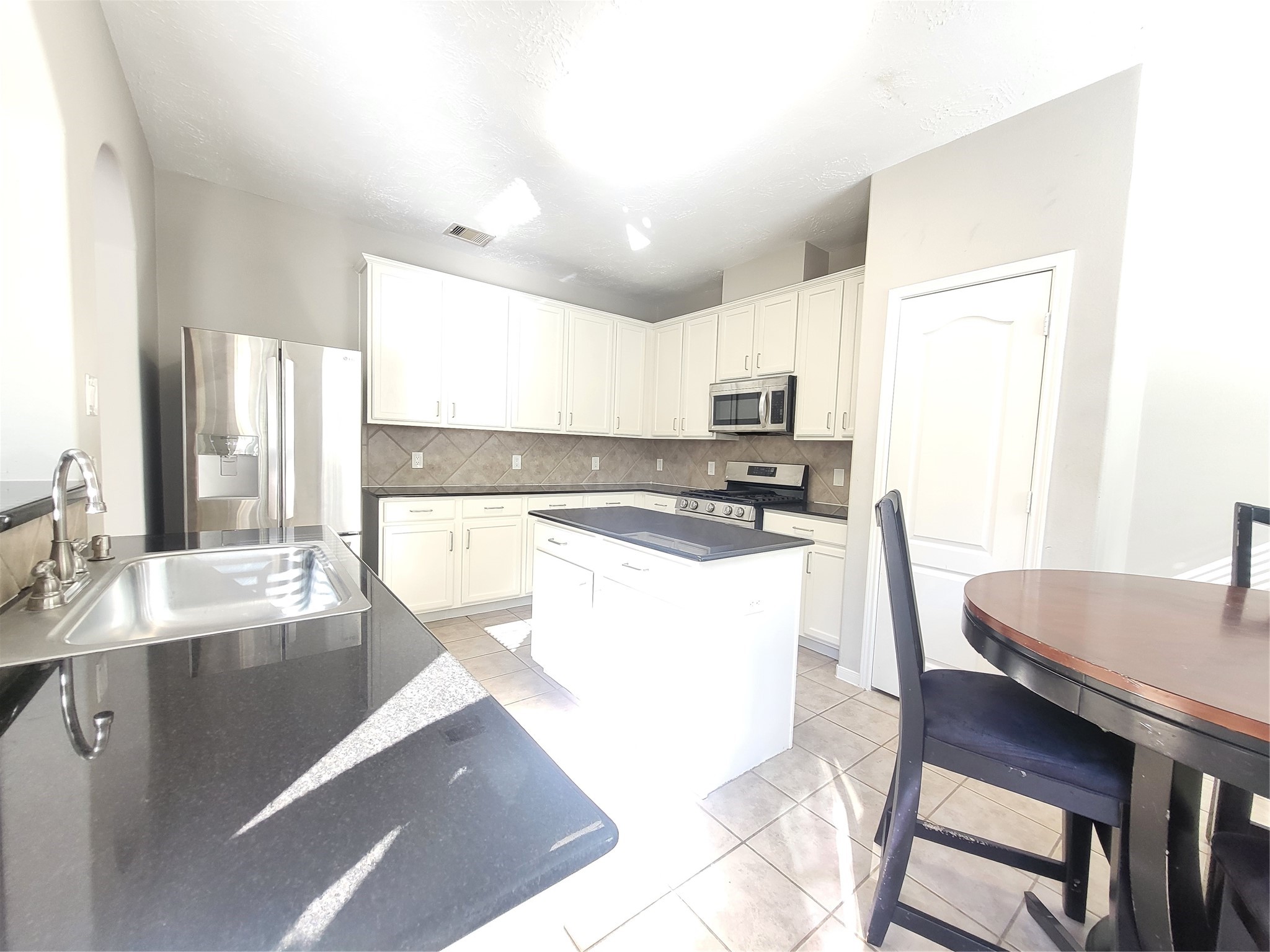 7415 Hollister Ridge Houston, TX 77040 - Photo 9 of 36 a living room with stainless steel appliances kitchen island granite countertop furniture and a kitchen view