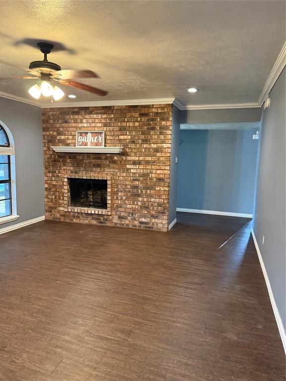 3801 Guthrie Road Garland, TX 75043 - Photo 6 of 24 Brick fireplace with a white mantel, wood-finish flooring, recessed lighting, and crown molding