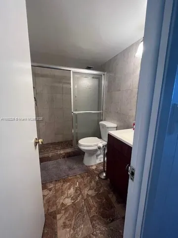 a bathroom with a toilet and a shower