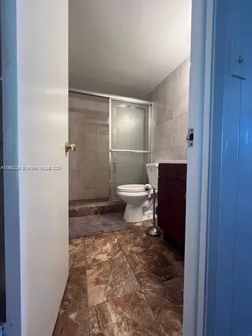 a bathroom with a toilet and a shower