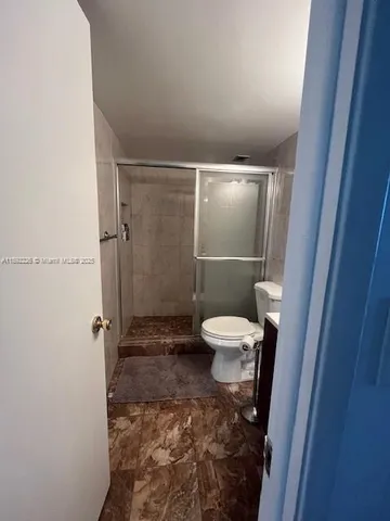 a bathroom with a toilet and a shower
