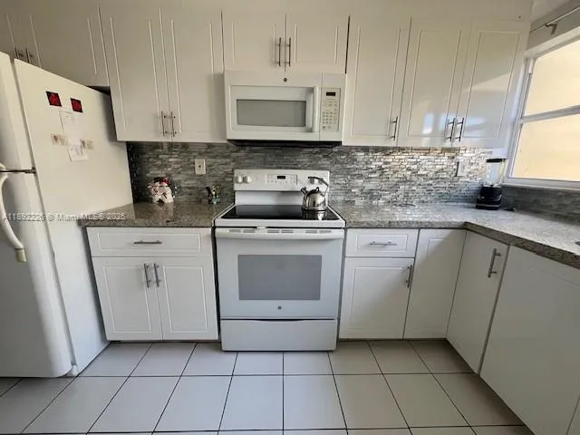a kitchen with cabinets appliances and a sink