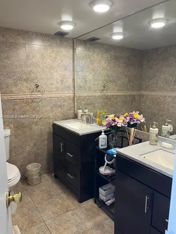 a bathroom with a sink vanity mirror and toilet