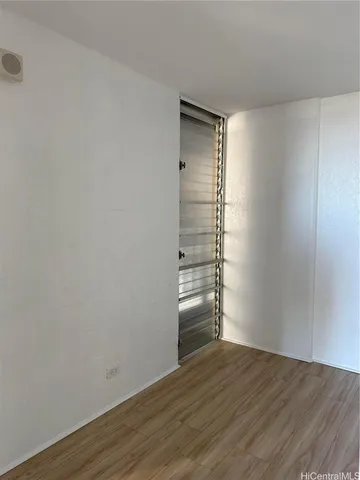 a view of empty room with wooden floor