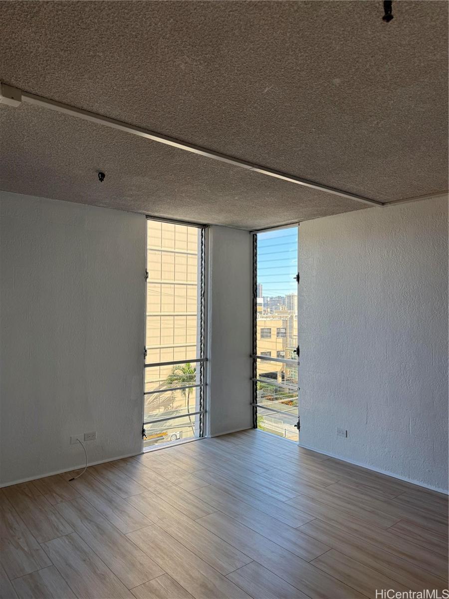 1226 Alexander Street, Unit 505 Honolulu, HI 96826 - Photo 5 of 24 a view of an empty room with wooden floor and a window