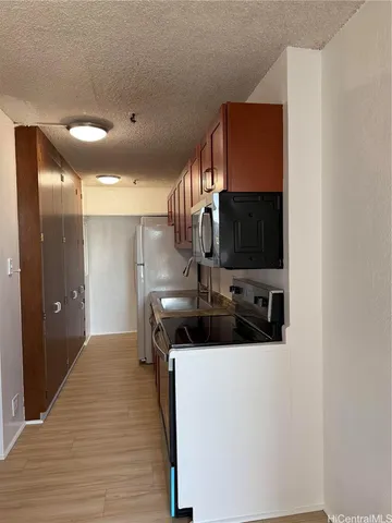 a kitchen with wooden cabinets and a stove top oven