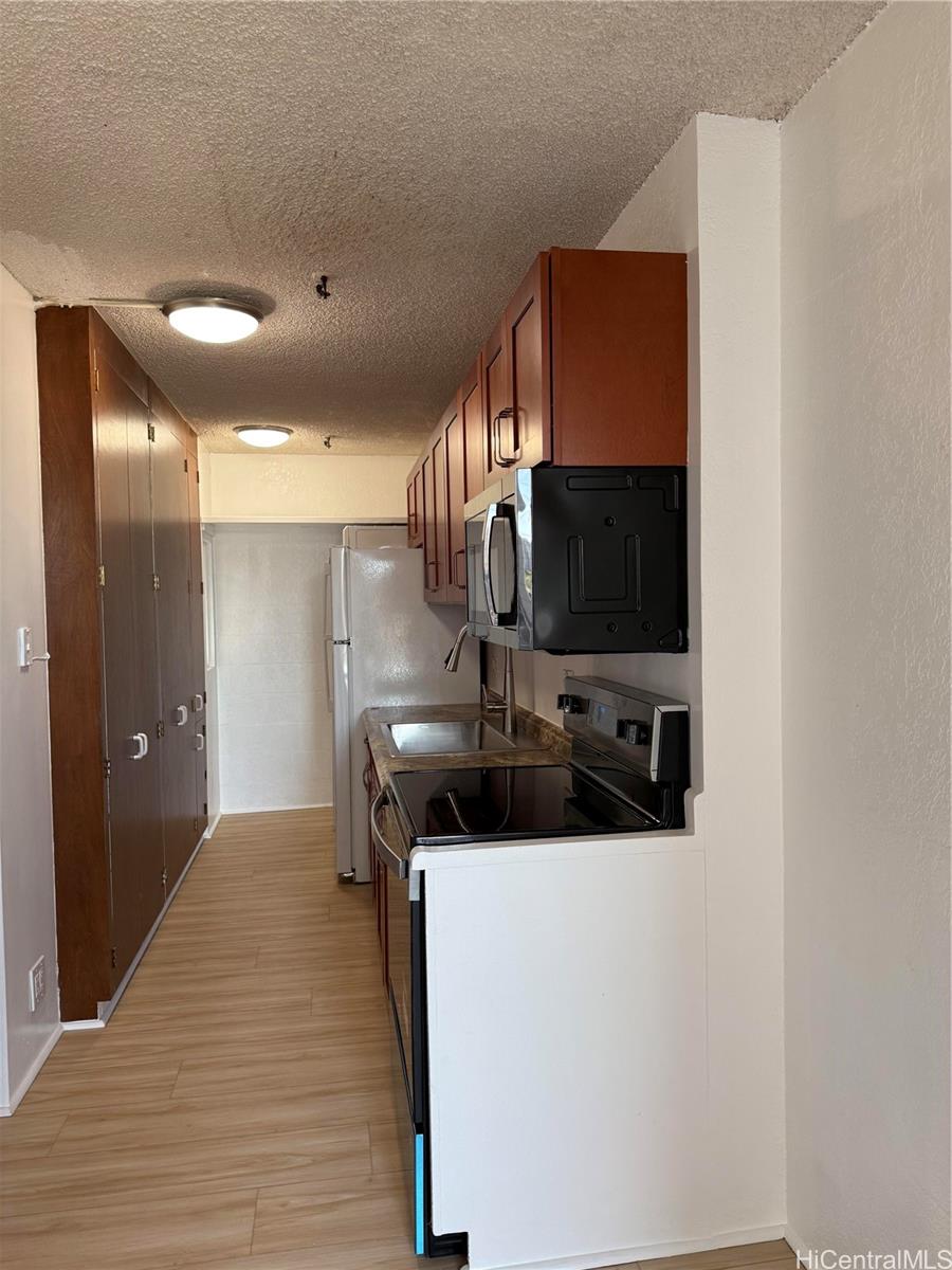 1226 Alexander Street, Unit 505 Honolulu, HI 96826 - Photo 8 of 24 a kitchen with stainless steel appliances a sink and a microwave