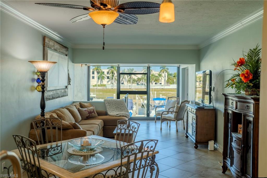 803 River Point Drive, Unit 105B Naples, FL 34102 - Photo 13 of 36 a living room with furniture a chandelier and a floor to ceiling window