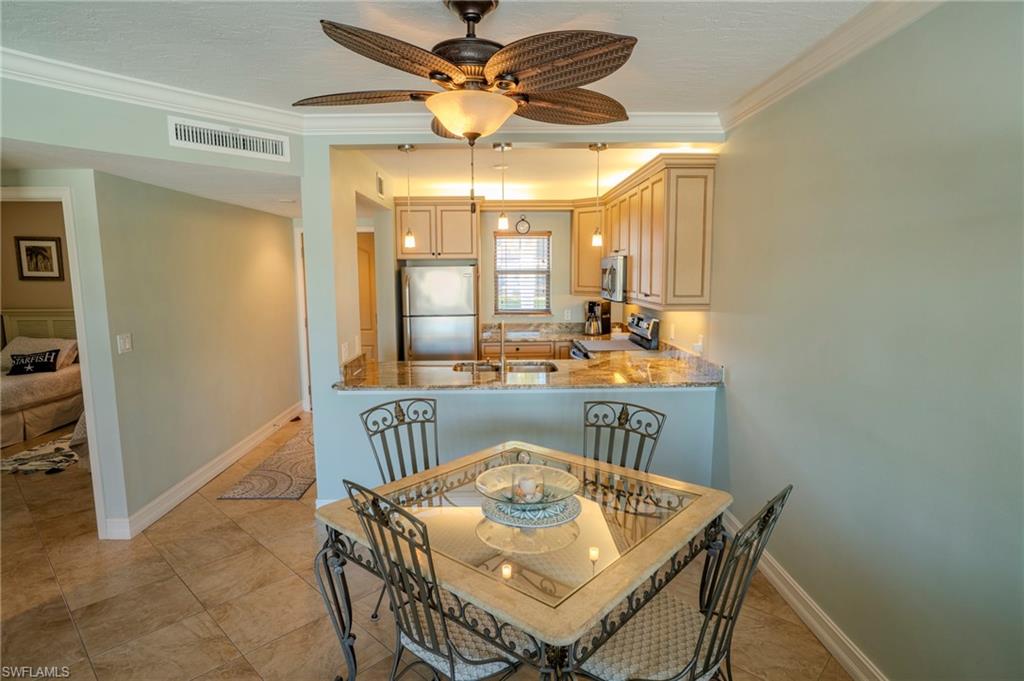 803 River Point Drive, Unit 105B Naples, FL 34102 - Photo 16 of 36 a view of a dining room with furniture and a chandelier
