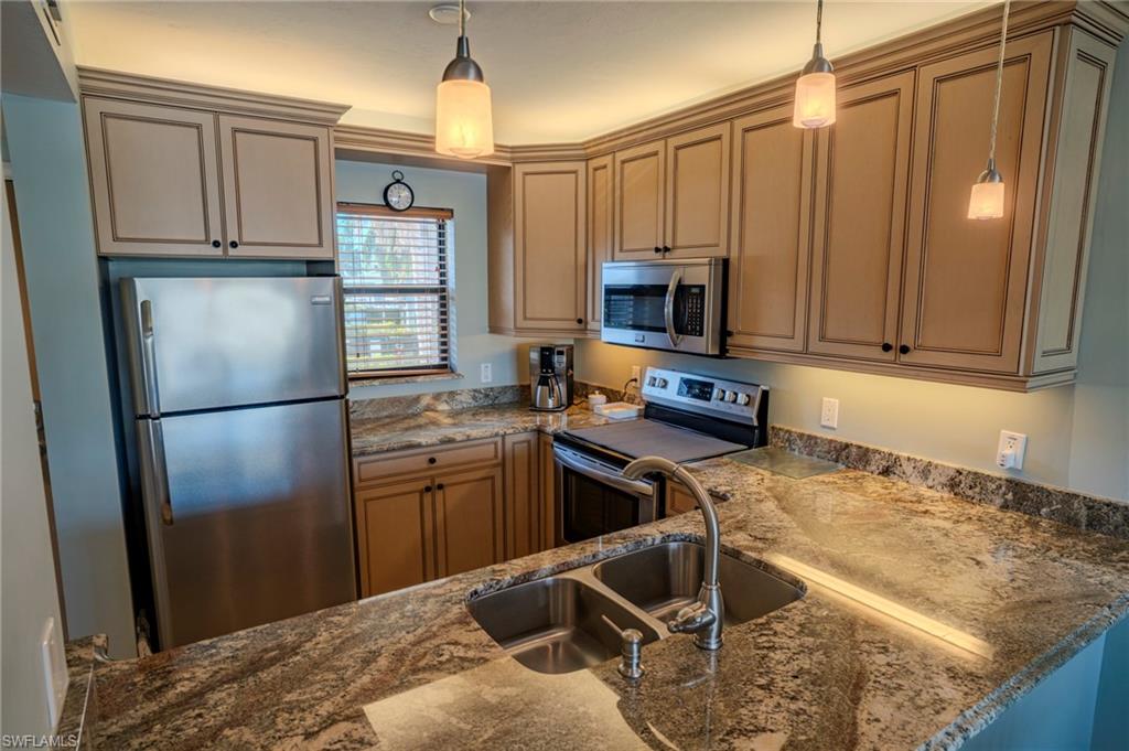 803 River Point Drive, Unit 105B Naples, FL 34102 - Photo 20 of 36 a kitchen with stainless steel appliances granite countertop a refrigerator stove and sink