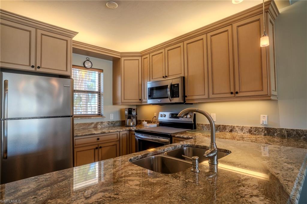 803 River Point Drive, Unit 105B Naples, FL 34102 - Photo 21 of 36 a kitchen with stainless steel appliances granite countertop a refrigerator sink and stove