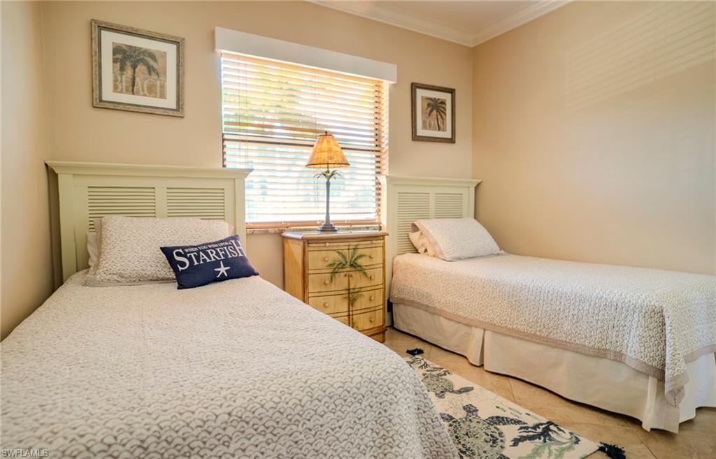 803 River Point Drive, Unit 105B Naples, FL 34102 - Photo 31 of 36 a bedroom with two beds and a window