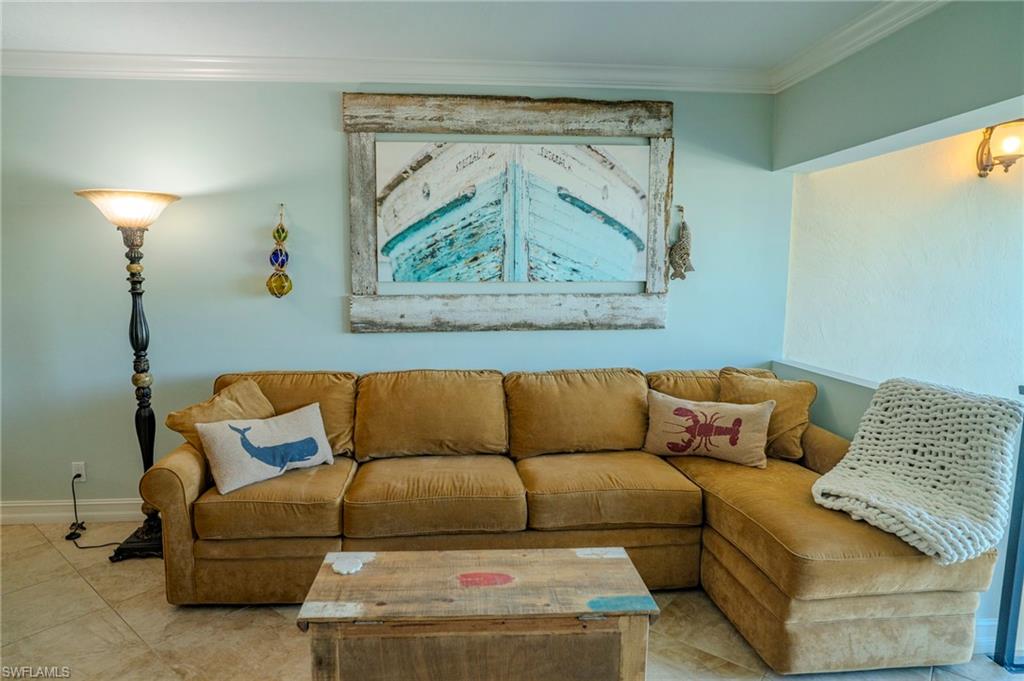 803 River Point Drive, Unit 105B Naples, FL 34102 - Photo 8 of 36 a living room with a couch and a painting on the wall