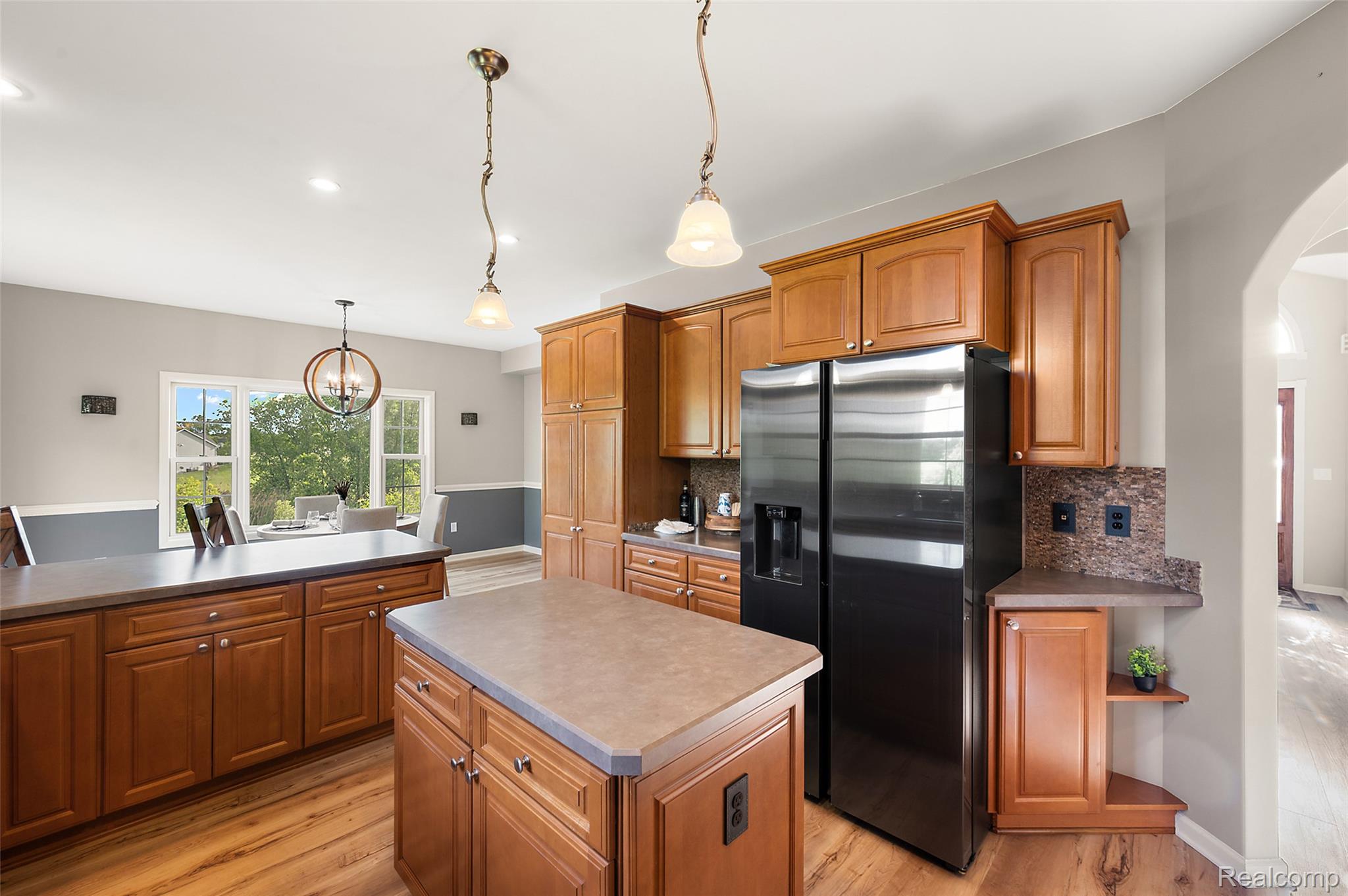 5035 Hidden Ridge Road Metamora, MI 48455 - Photo 20 of 65 Spacious kitchen featuring wood-finish flooring, abundant cabinetry, a central island, and a stainless steel refrigerator