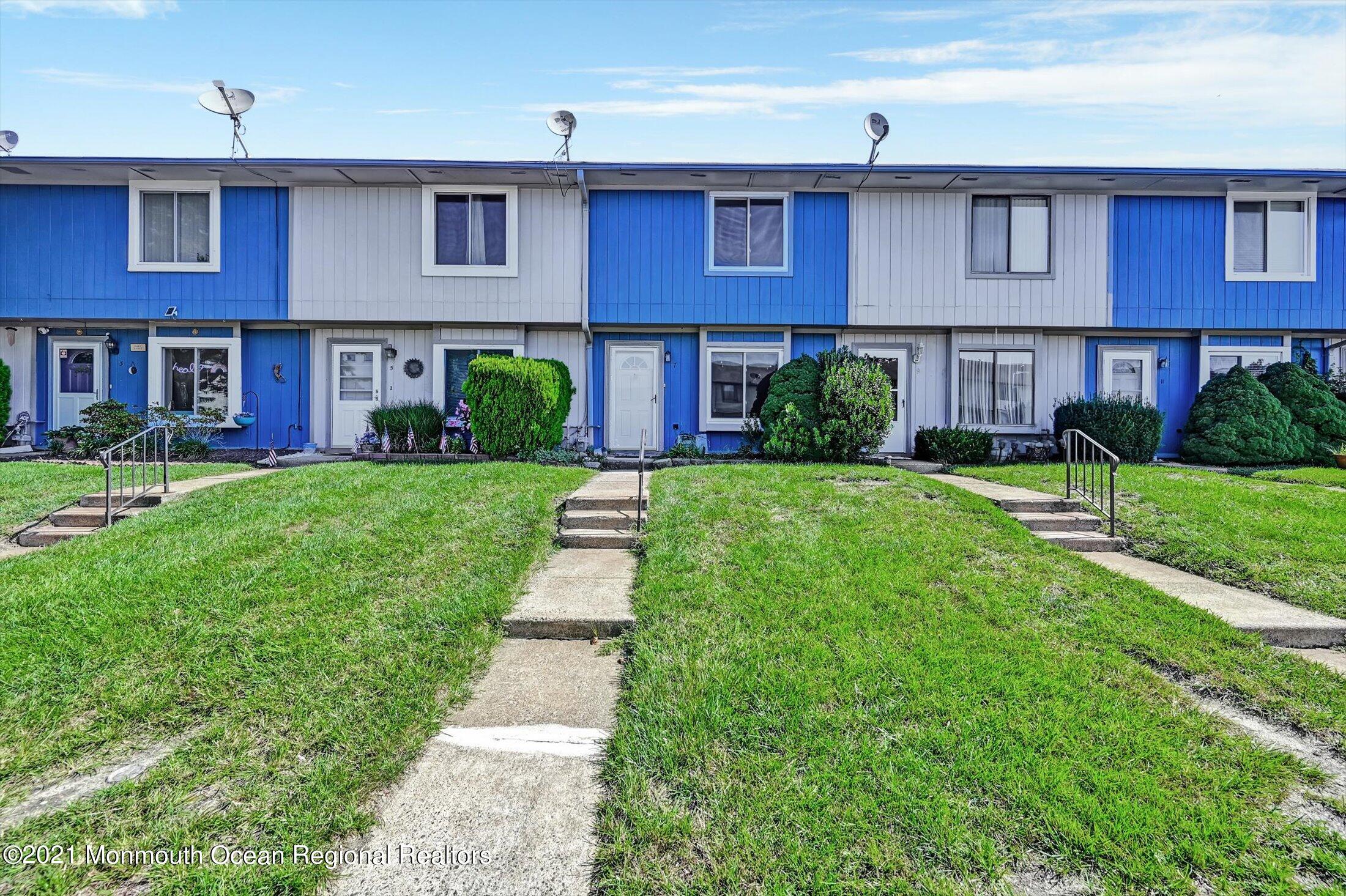 a view of a brick building and yard with large trees