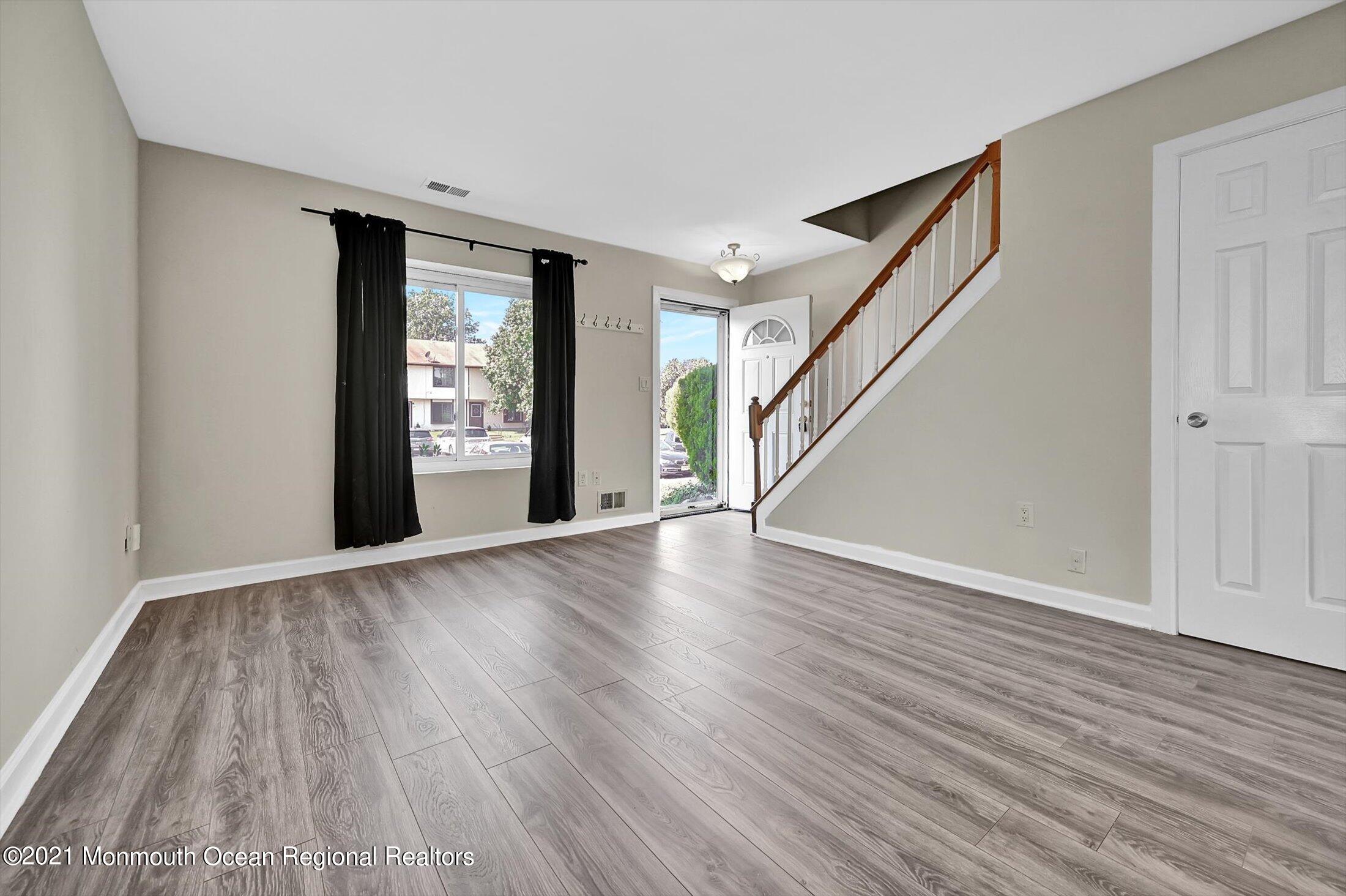 7 Creek Road Brick, NJ 08724 - Photo 3 of 14 a view of an empty room with wooden floor and stairs