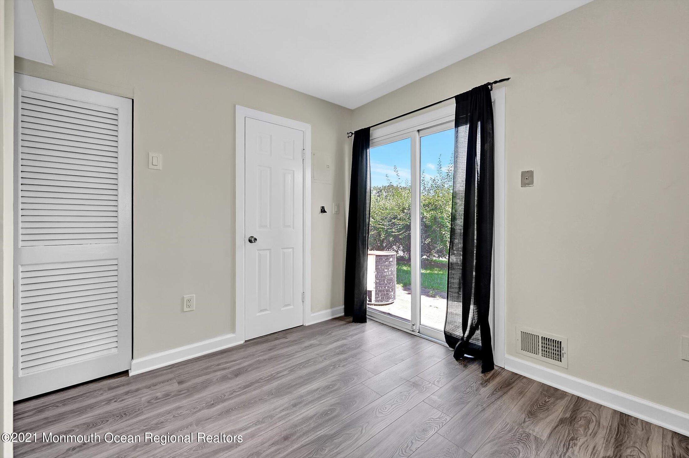 7 Creek Road Brick, NJ 08724 - Photo 7 of 14 an empty room with wooden floor and windows
