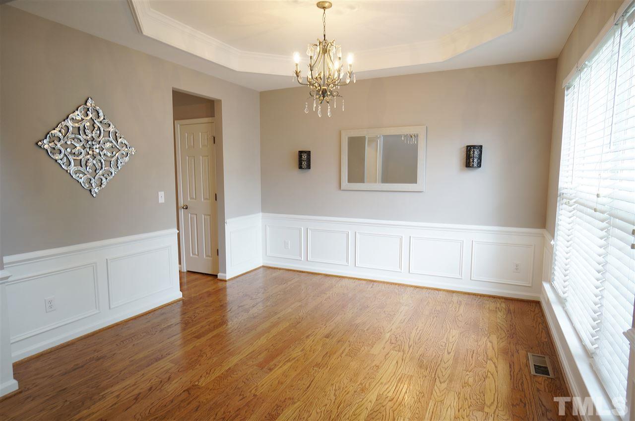 7730 San Gabriel Street Raleigh, NC 27613 - Photo 2 of 25 Dining room showcases stunning hardwood floors, brilliant wainscoting, tray ceiling & a beautiful backdrop for any mea