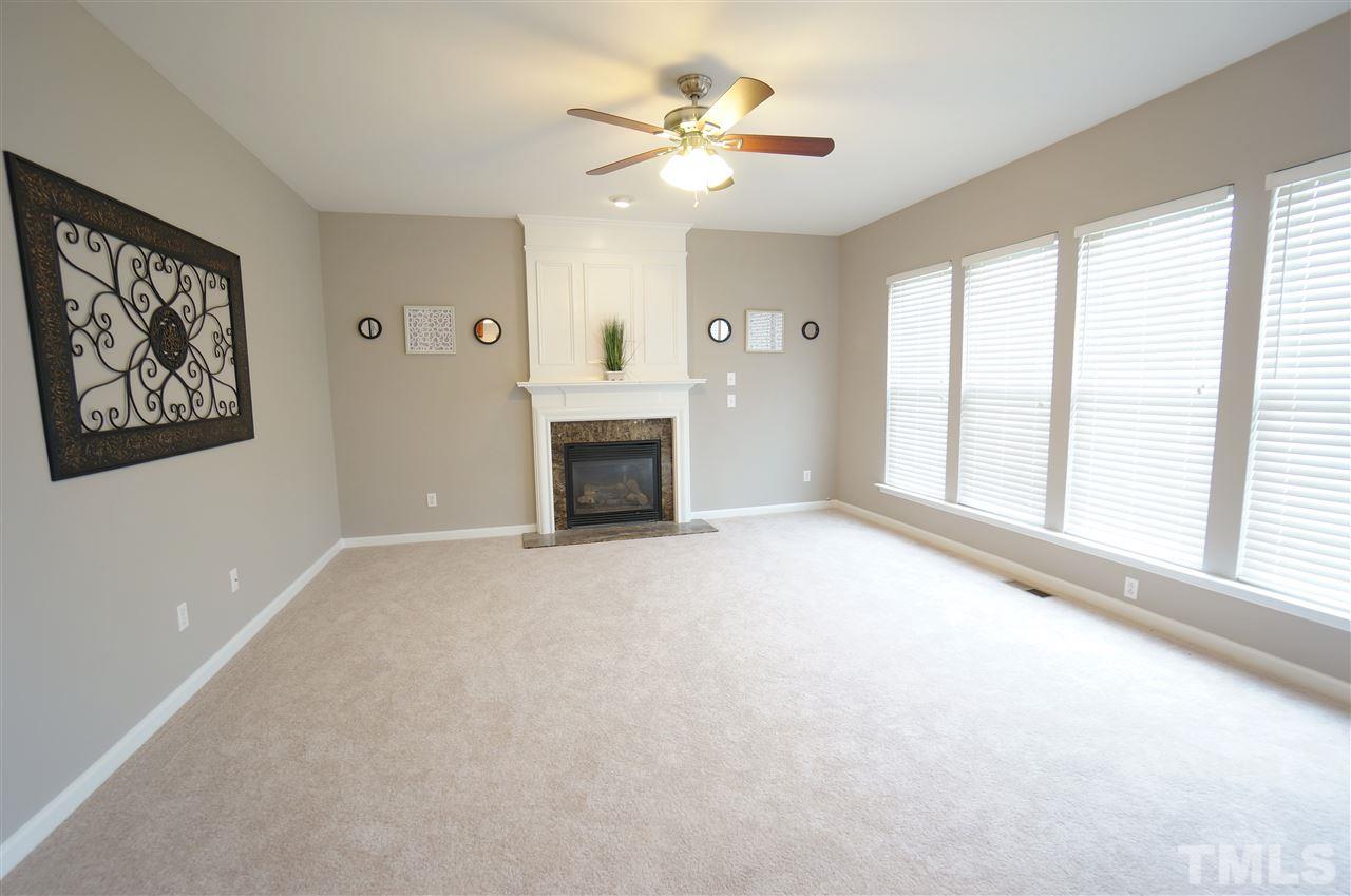 7730 San Gabriel Street Raleigh, NC 27613 - Photo 11 of 25 Living room is showered by soft, beautiful natural lighting. Fireplace is an attractive focal piece that grounds the space nicely.