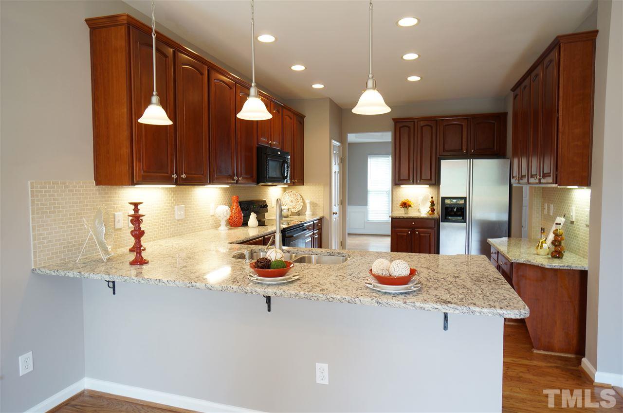 7730 San Gabriel Street Raleigh, NC 27613 - Photo 6 of 25 Breakfast bar is a perfect gathering spot & beautiful segue to the bright breakfast room.