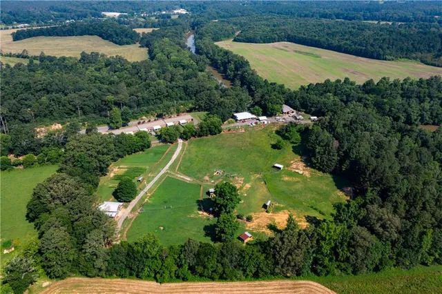 an aerial view of residential houses with outdoor space and trees all around
